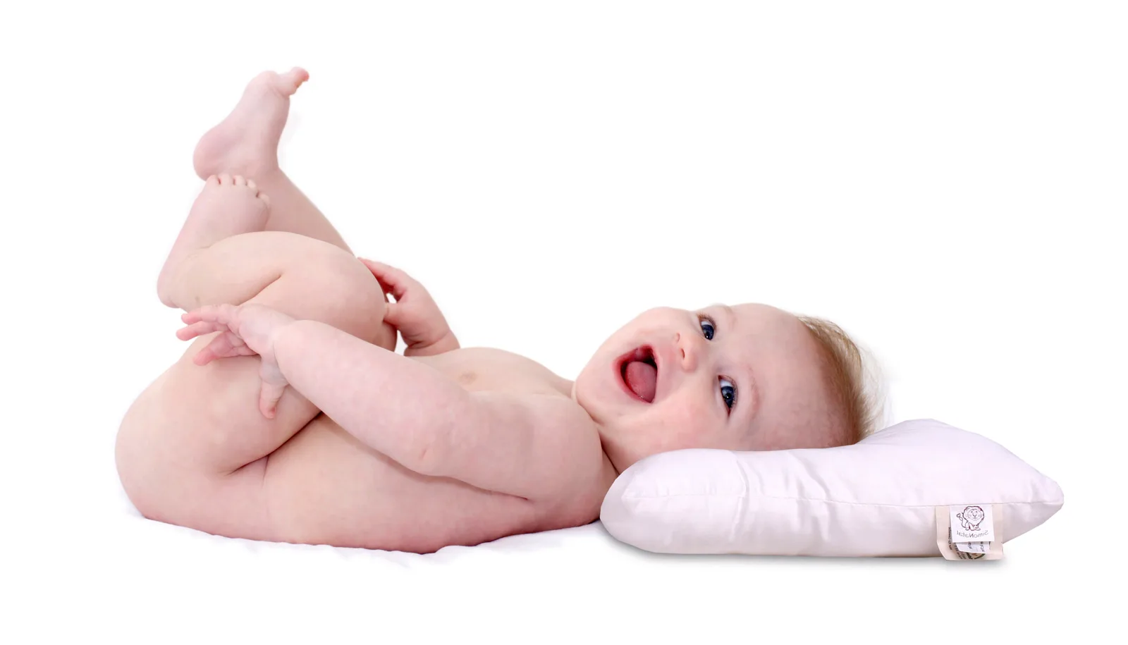 Neonato sorridente sdraiato con la testa sul cuscino Bimbodorm